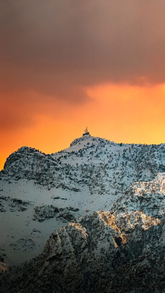 a snow covered mountain under a cloudy sky